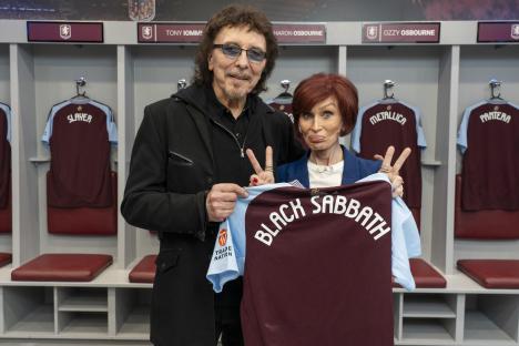 Tony Iommi and Sharon Osbourne holding a Black Sabbath jersey.