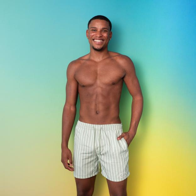 Smiling man in striped swim shorts.