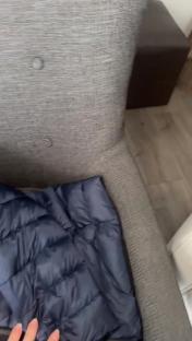 A dark blue puffer jacket on a gray chair.