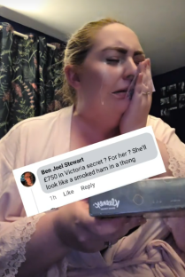 Screenshot of a woman crying while reading an offensive comment on her phone.