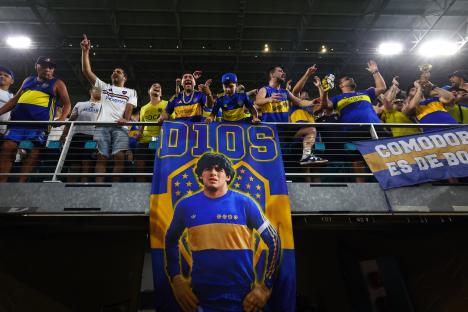 Boca Juniors fans holding a banner of Diego Maradona.