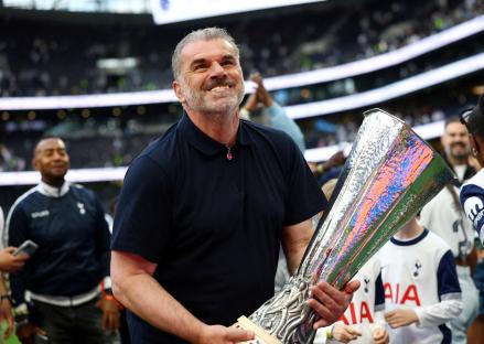 Ange Postecoglou holding the Europa League trophy.
