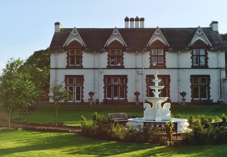 Large house with fountain in front.