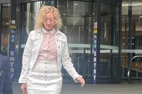 A pregnant teacher leaving a courthouse.