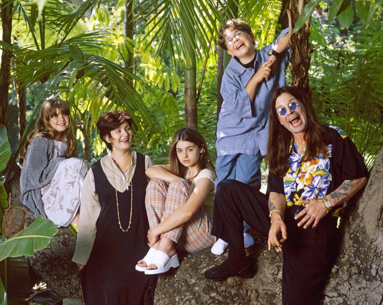 Ozzy Osbourne with his family on a tree trunk.