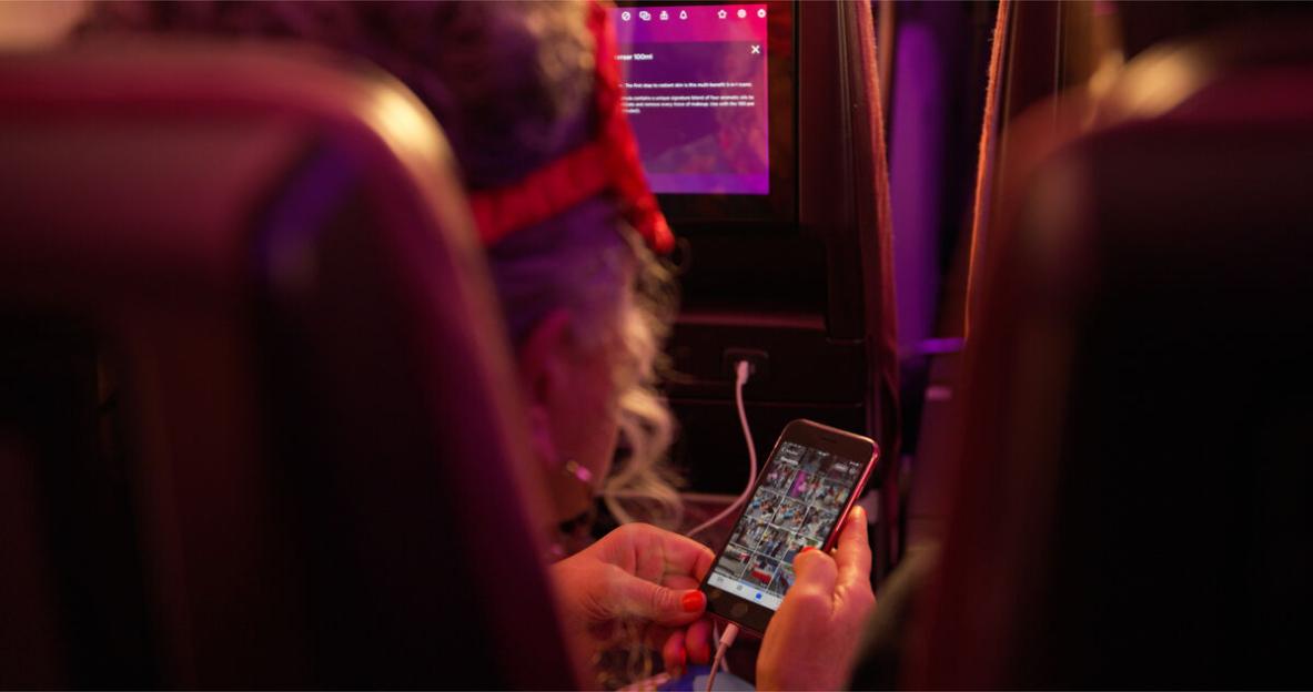 Person viewing photos on a smartphone in a vehicle.