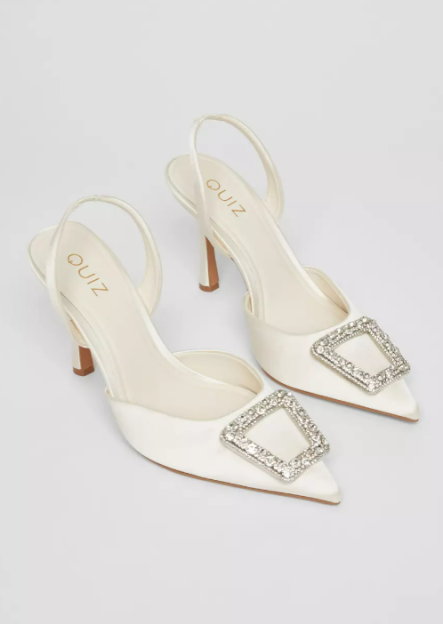 Pair of white satin slingback heels with jeweled buckles.