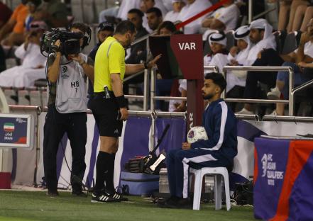Referee using VAR during a soccer match.