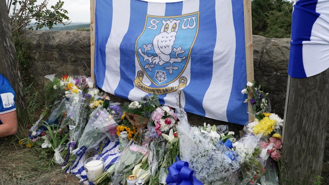 Tributes and flowers at a roadside memorial.