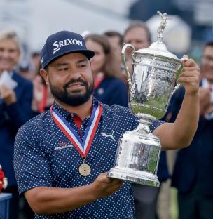 J.J. Spaun of the USA holding the US Open golf tournament trophy.