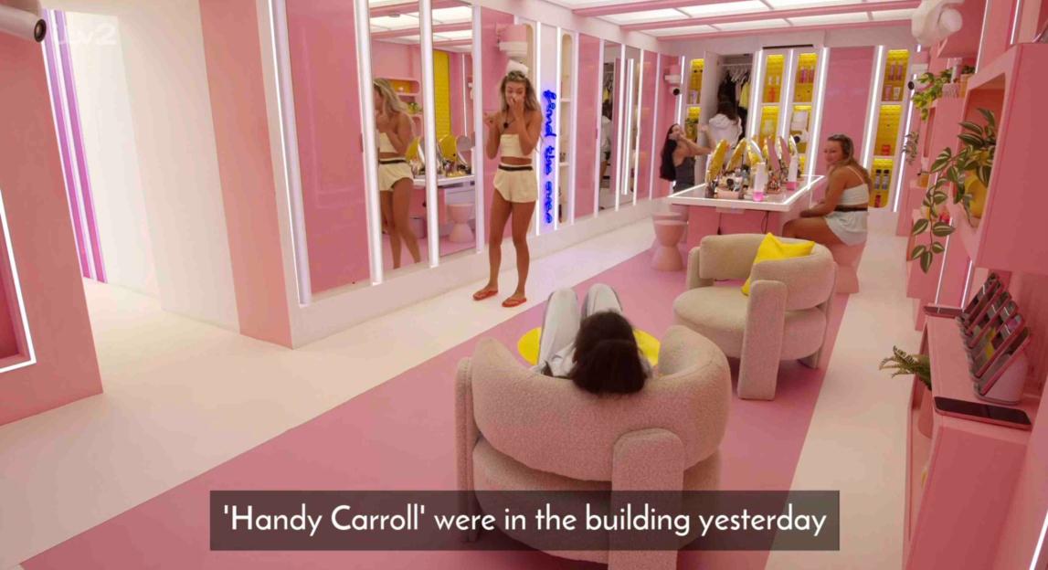 Screenshot of women in a pink room.
