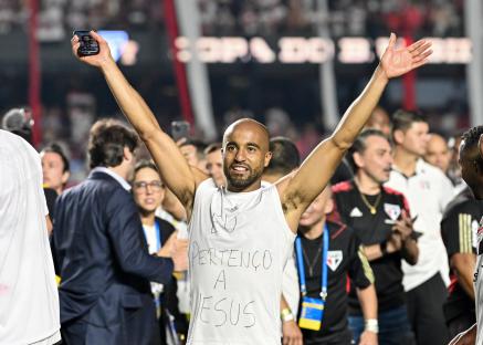 Lucas Moura celebrating a win, arms raised, wearing a shirt that says