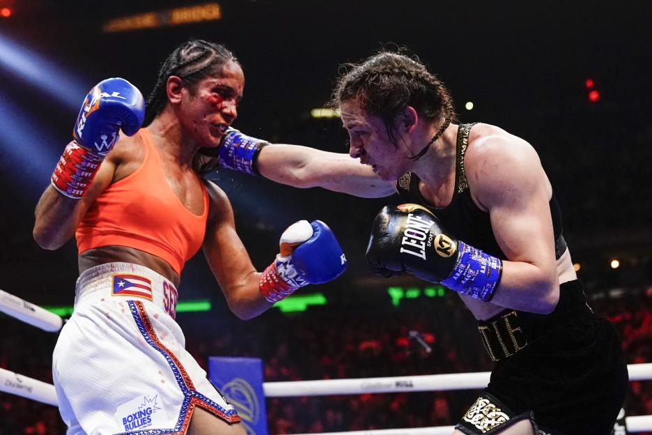 Katie Taylor punches Amanda Serrano in a boxing match.