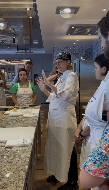 Chef instructing a cooking class on a cruise ship.