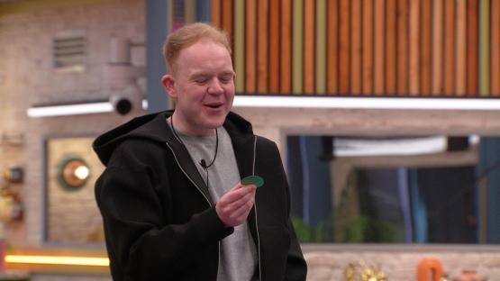 Colson Smith on Celebrity Big Brother holding a game piece.
