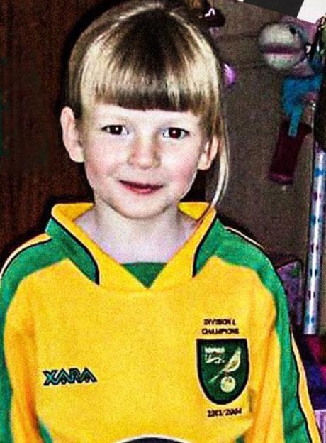 Young girl in a yellow and green soccer jersey.