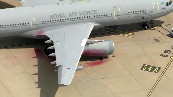 A Royal Air Force plane with red paint splattered on its wing and engine.