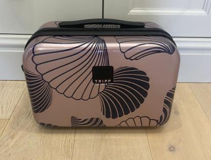 Rose gold cosmetic case with black shell pattern.
