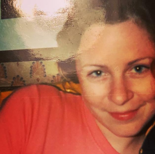 Photo of a woman in a coral shirt.