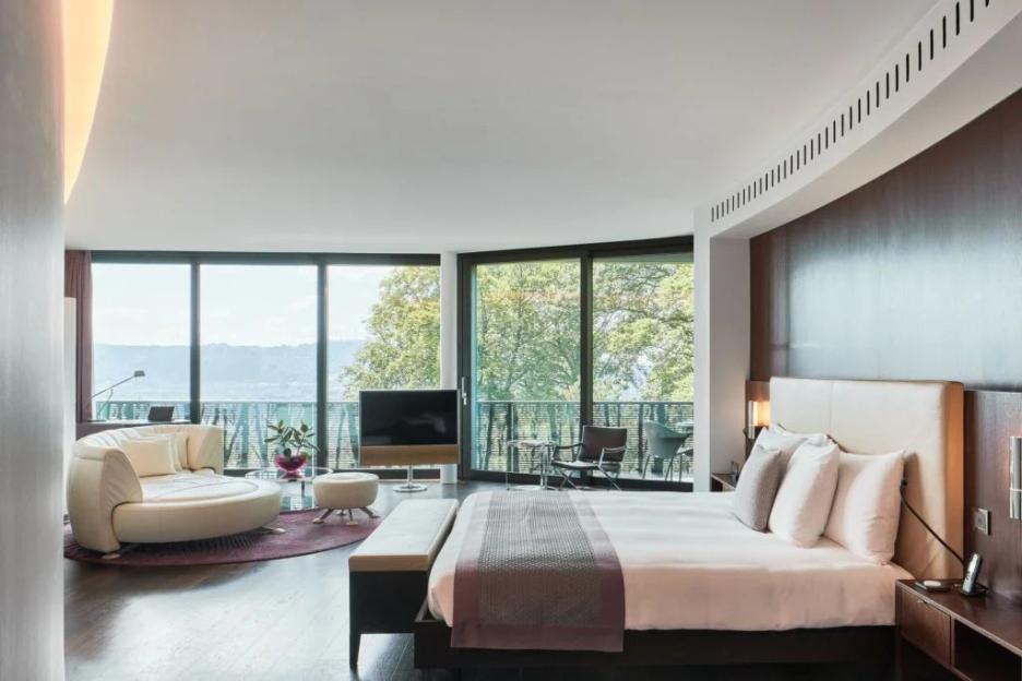 Hotel room with large windows overlooking a scenic view.