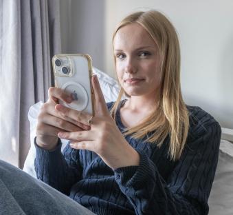 Teenage girl using a mobile phone in her bedroom.