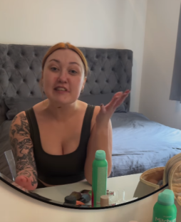 Woman with tattoos talking to the camera while getting ready.