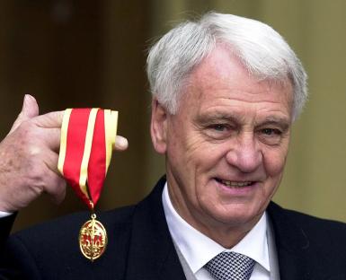 Sir Bobby Robson holding his knighthood medal.