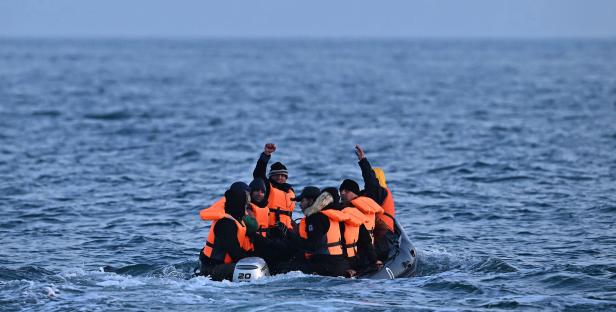 Migrants in a small boat at sea.
