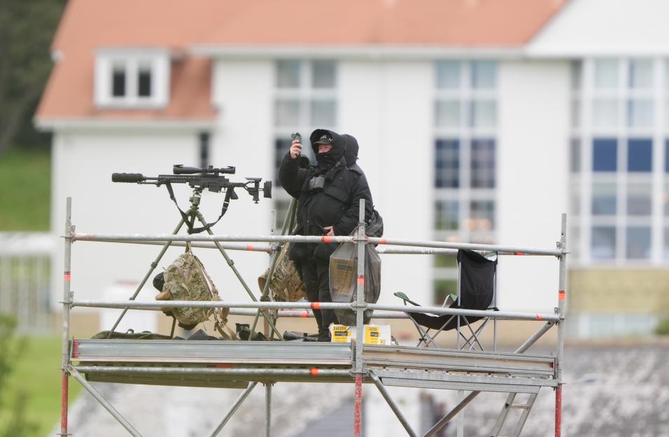 Police officer on scaffolding with a rifle.