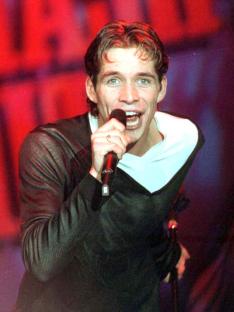 Photo of Sean Maguire singing into a microphone.