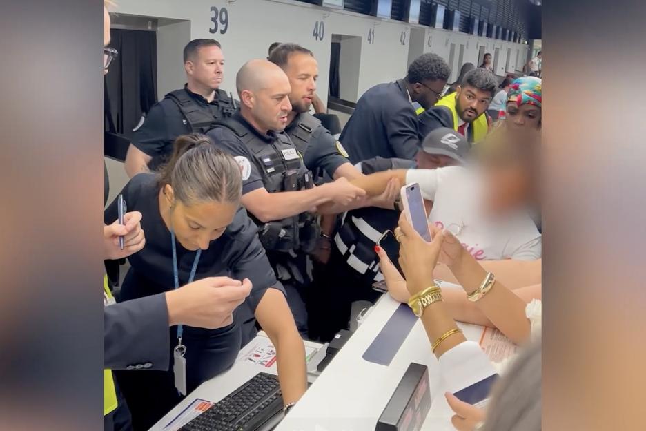 Airport security subdues a disruptive passenger.