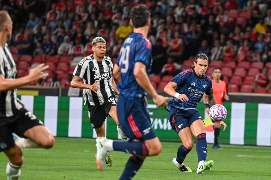 Arsenal's Riccardo Calafiori kicking a soccer ball during a match.