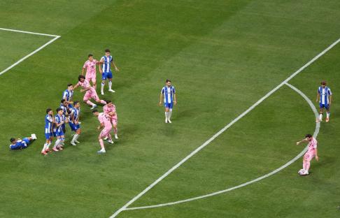Lionel Messi taking a free kick in a soccer game.