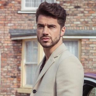 Sam Robertson in a light beige coat.