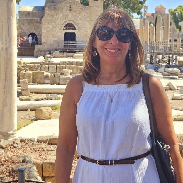 Woman in white dress at ancient ruins.