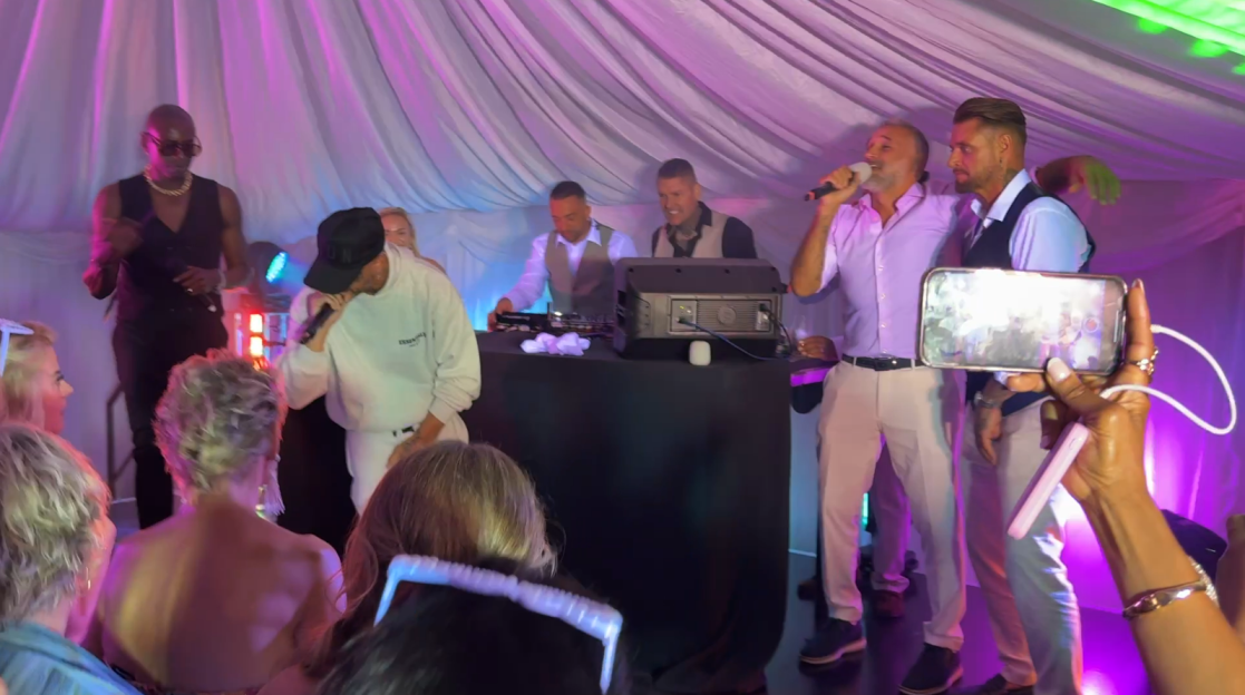 Performers singing and rapping at a party.