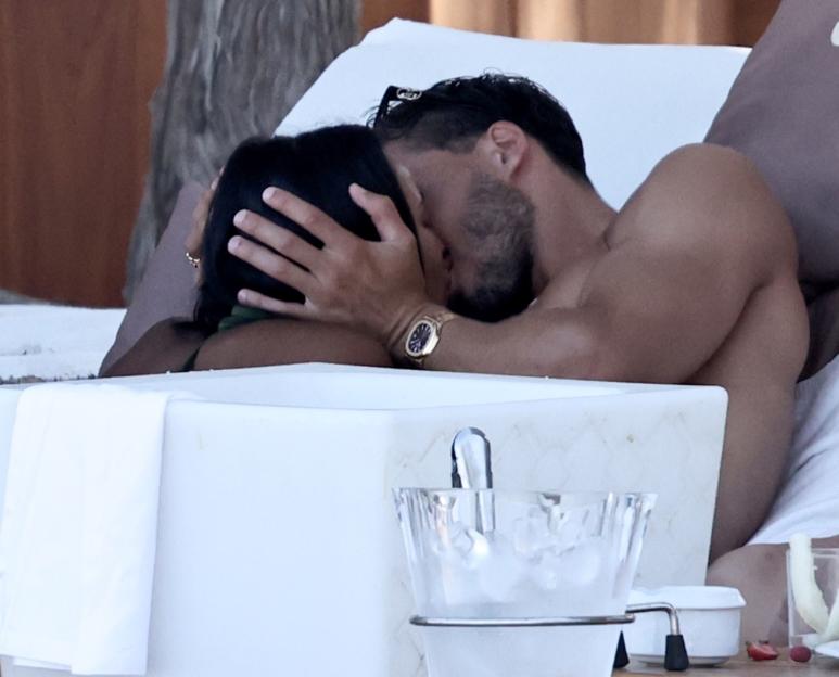 Maya Jama and Ruben Dias kissing on a sunbed.