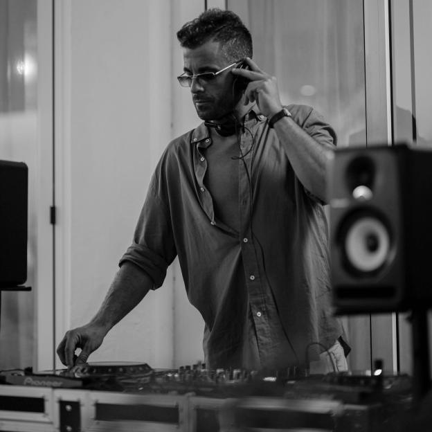 Black and white photo of DJ Godzi at a mixing console.