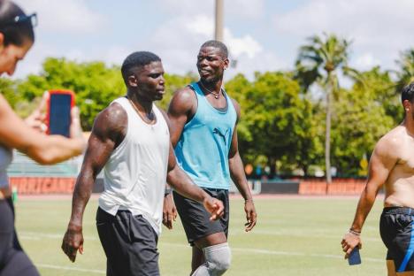 Paul Pogba and other athletes walking on a field.