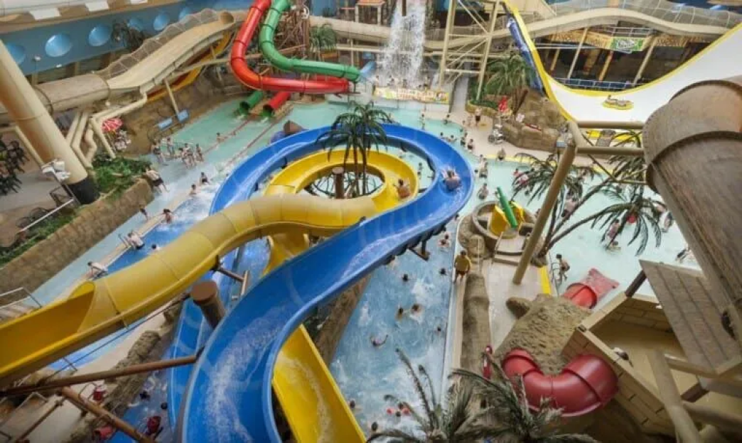 Indoor water park with multiple slides and pools.