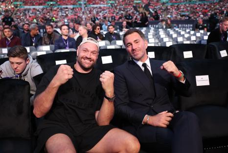Tyson Fury and Eddie Hearn seated together at a boxing event.