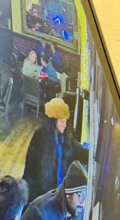 CCTV image of a missing woman wearing a tan hat in a pub.