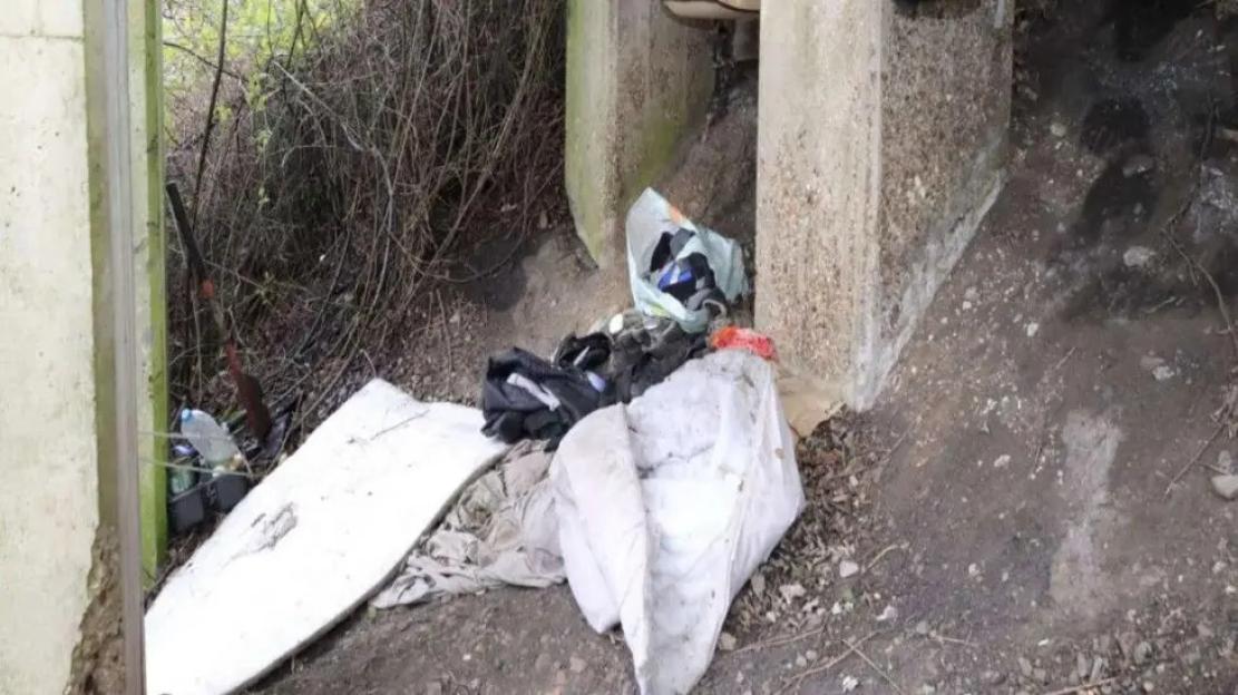 Discarded items under a bridge.