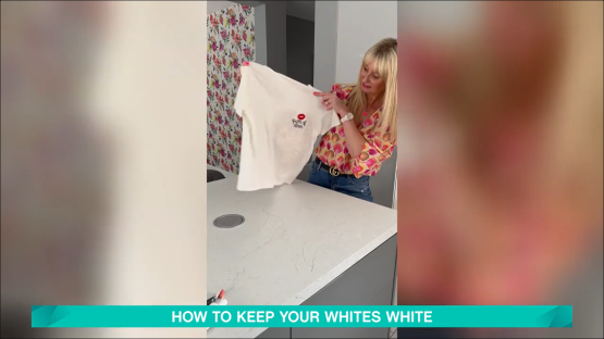 Woman holding up a white t-shirt with red lips and text that says