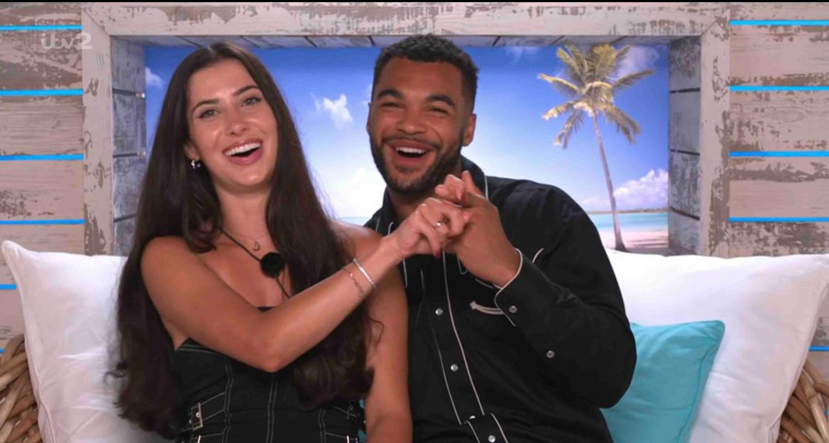 Yasmin and Jamie from Love Island holding hands and laughing.