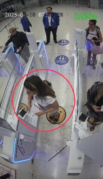 Overhead security camera view of a woman using a self-service kiosk.
