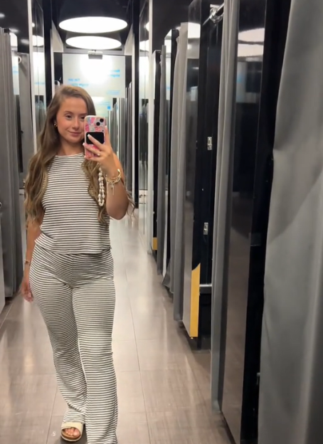 Woman in striped pants and top in a Primark changing room.