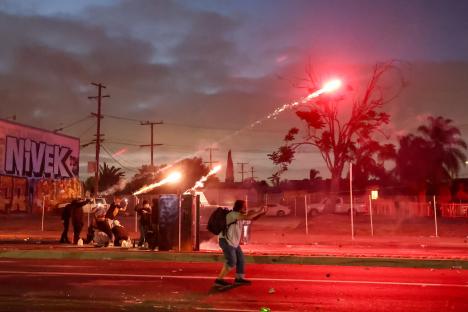 Protesters clashing with law enforcement during a demonstration against immigration raids.