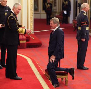 Sir Kenny Dalglish being knighted by the Prince of Wales at Buckingham Palace.