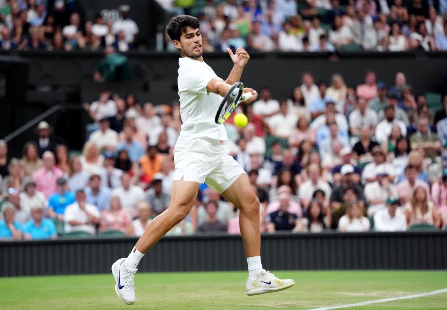 Carlos Alcaraz playing tennis at Wimbledon.